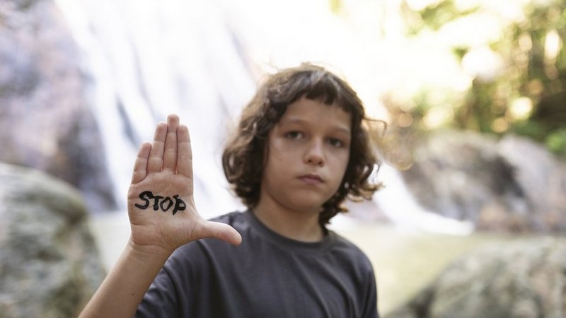 Junge mit der Aufschrift "Stop" auf der Hand