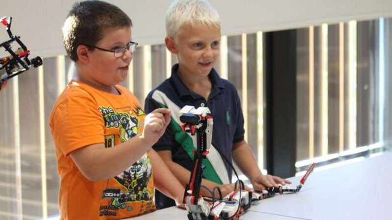 zwei junge Burschen bauen eine Roboterschlange