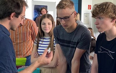 Wissenschaftsbotschafter Dr. Martin Ringbauer zeigt  Schülern und Schülerinnen die Ionenfalle. Herzstück eines Quantencomputers