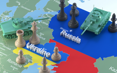 Plastik Panzer und Schachfiguren gegeneinander gerichtet auf einer Landkarte von der Ukraine und Russland