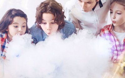 Vier Kinder blasen Rauch aus